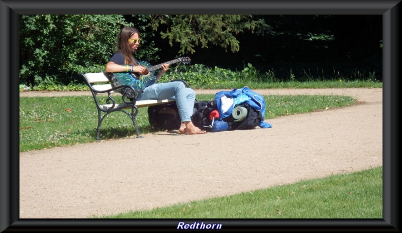 Mochilero tocando la guitarra en el parque Lazienki