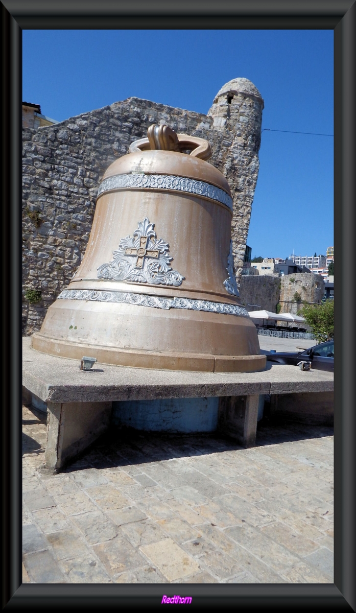 Monumental campana delante de las murallas de Budva