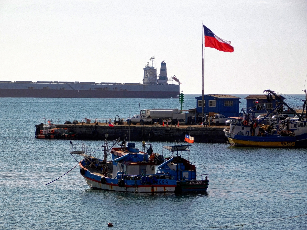 Esquina del muelle de pescadores con un barco de fondo