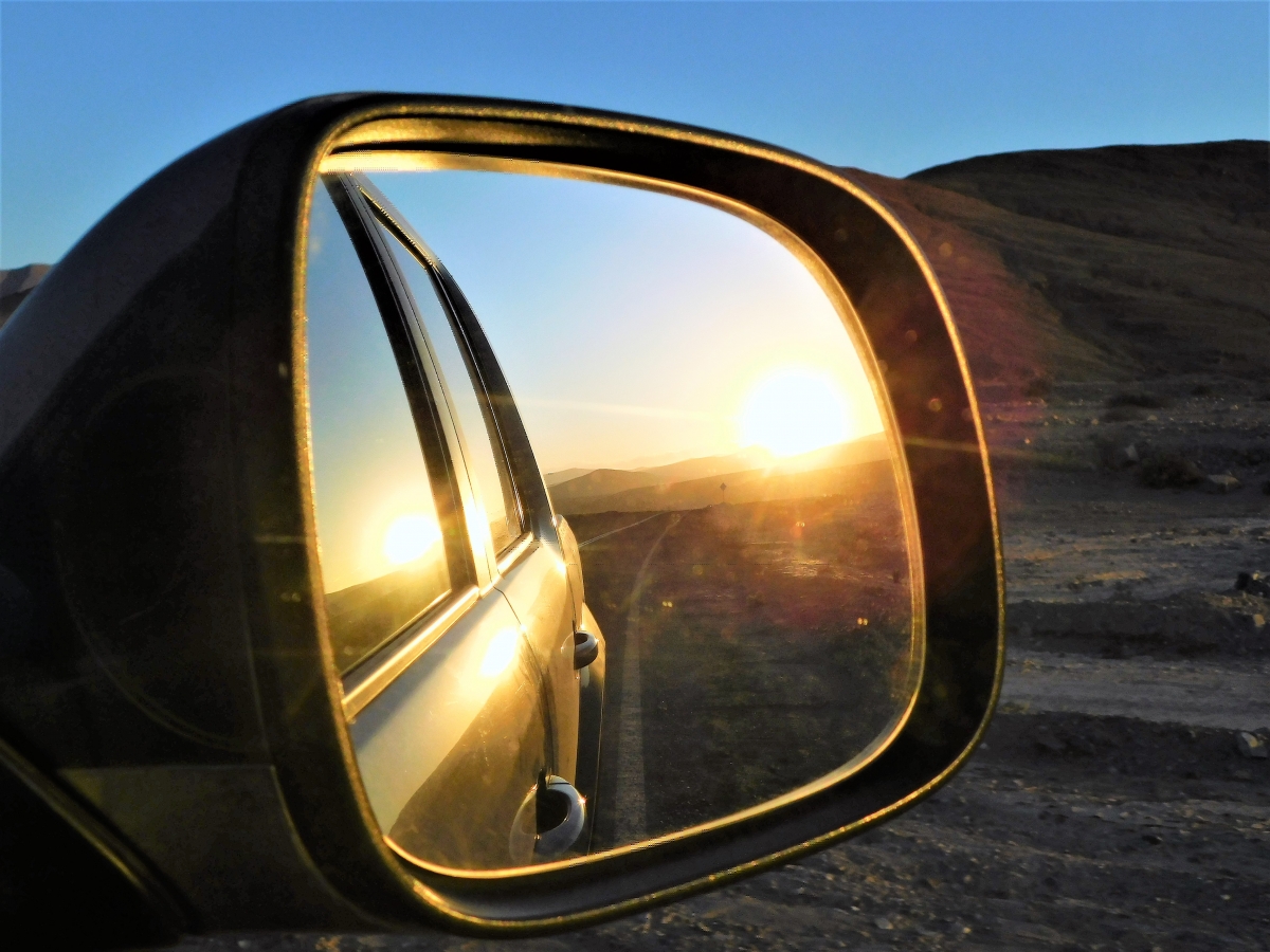 El sol reflejado en el espejo del auto