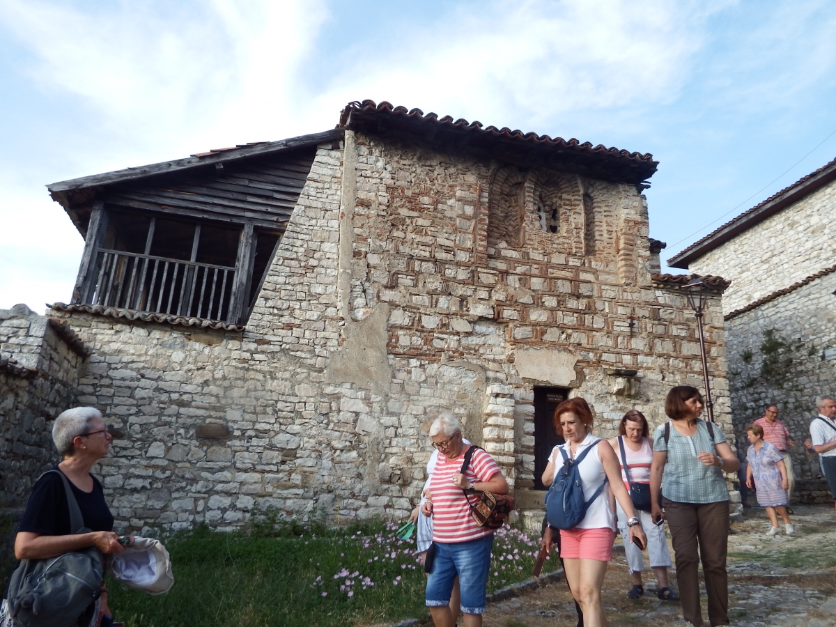 Compaeros del grupo pasan junto a una las casas tpicas Berat