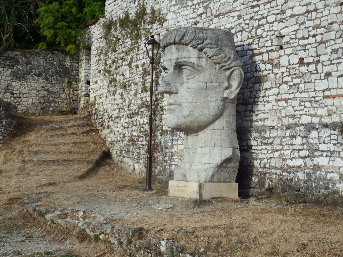 Monumental escultura de una cabeza junto a una esquina del Berat medieval