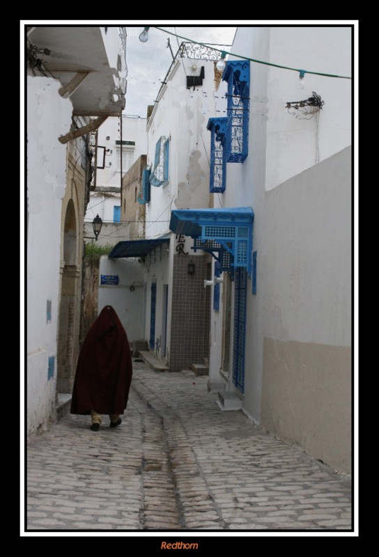 Alguin oculto en una capa se adentra por las tortuosas callejuelas de la medina de Sousse