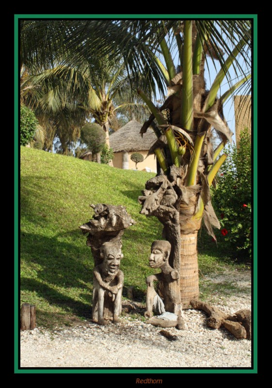 Esculturas africanas junto a palmera