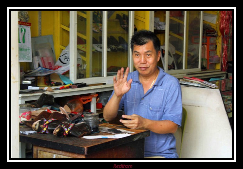 El artesano fabricante de zapatos chinos nos saluda amablemente