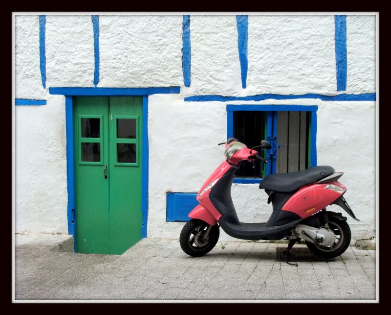 Moto roja junto a la puerta verde