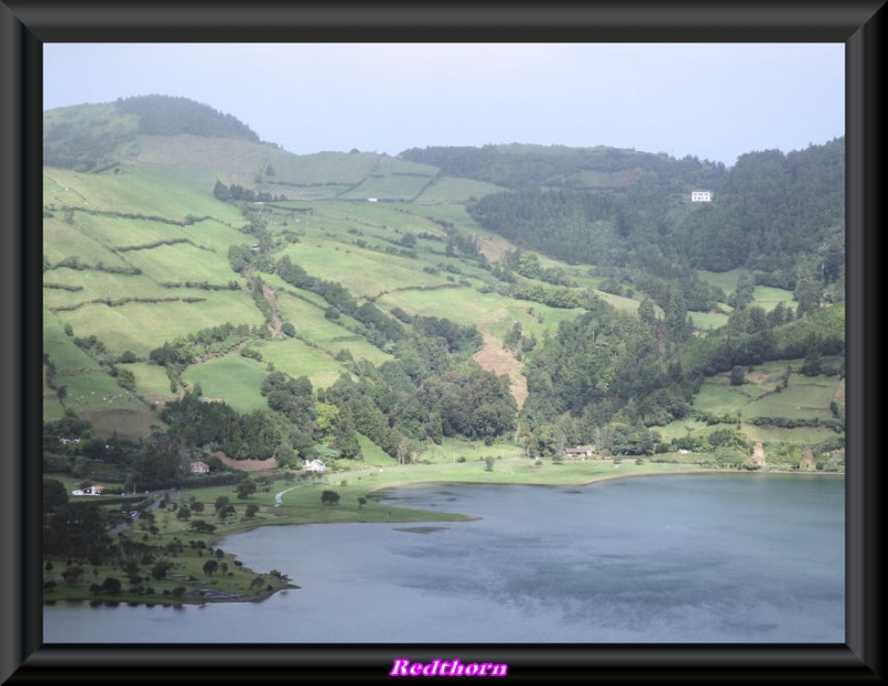 La lagoa verde rodeada de suaves colinas verdes